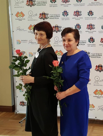 Divas sievietes ar ziediem